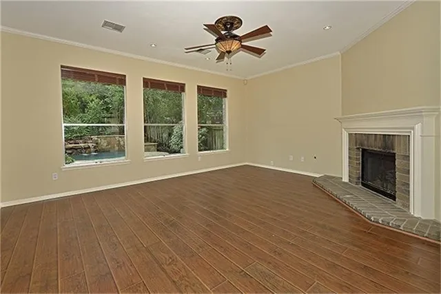 a view of empty room with wooden floor and fireplace