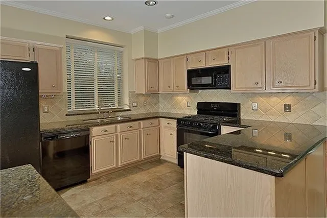 a kitchen with granite countertop a sink stove and cabinets