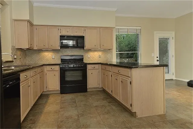 a kitchen with granite countertop white cabinets and stainless steel appliances