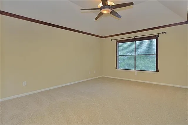 an empty room with a window and a ceiling fan