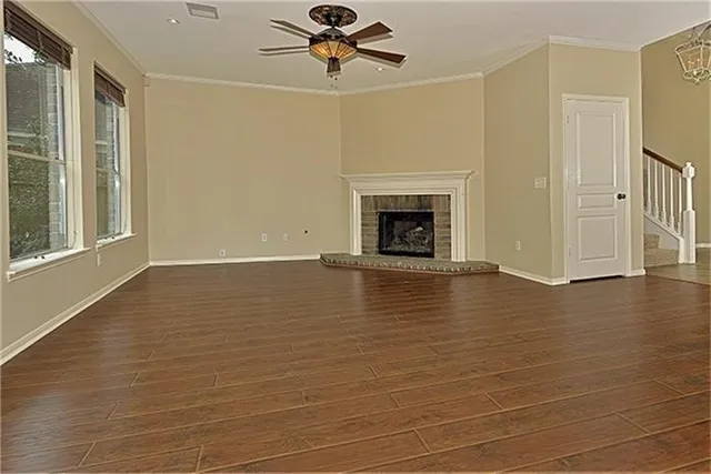 a view of empty room with wooden floor and fireplace