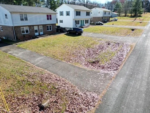 a view of a white house with a yard patio and wooden fence