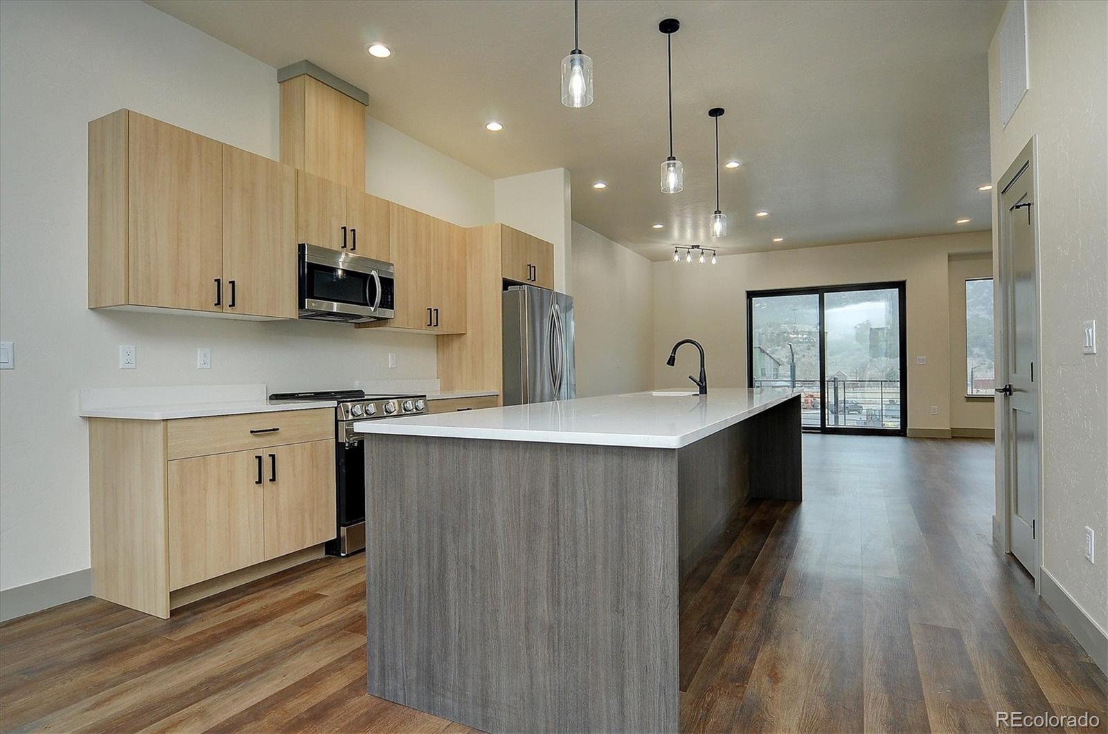 6398 Cleora Road, Unit G Salida, CO 81201 - Photo 6 of 34 a large kitchen with stainless steel appliances granite countertop a lot of counter space and wooden floor