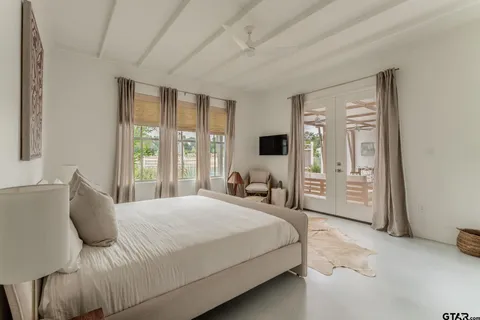 a bedroom with a bed and a large window