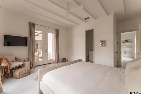 a bedroom with a balcony a bed and a flat tv screen