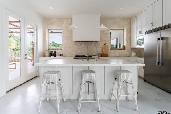 a spacious bathroom with a double vanity sink a mirror a window and a bathtub