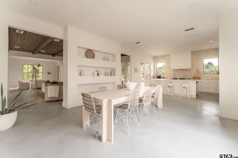 a living room with furniture a dining table and chairs