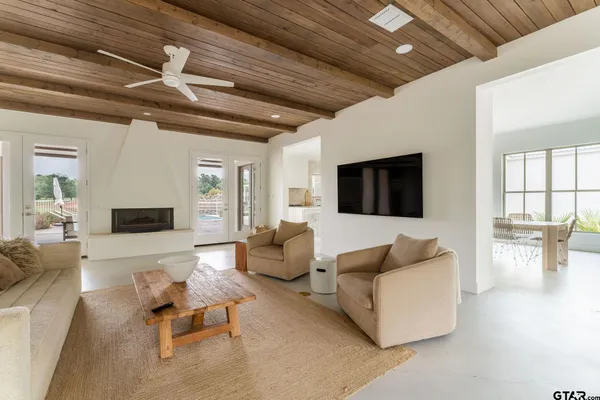 a living room with furniture and white walls with wooden floor