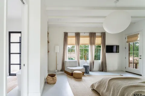 a bedroom with a bed and a couch next to a window