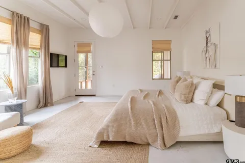 a bedroom with a bed and a large window