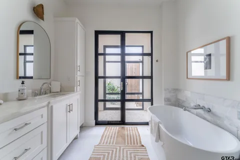 a bathroom with a tub sink and mirror