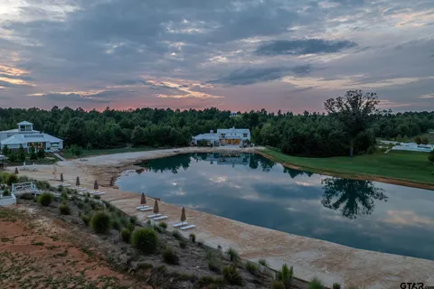 a view of a lake with a yard and wooden fence