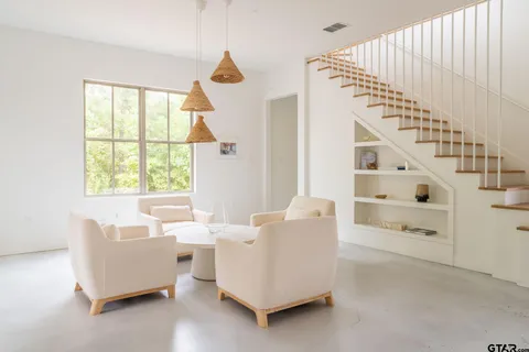 a living room with furniture and white walls with wooden floor