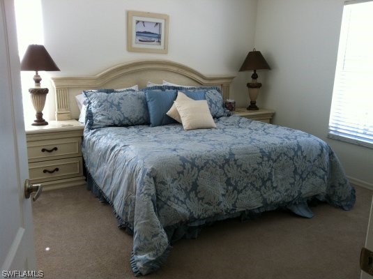 8088 Ibis Cove Circle, Unit 804 Naples, FL 34119 - Photo 11 of 27 a bedroom with a bed and window