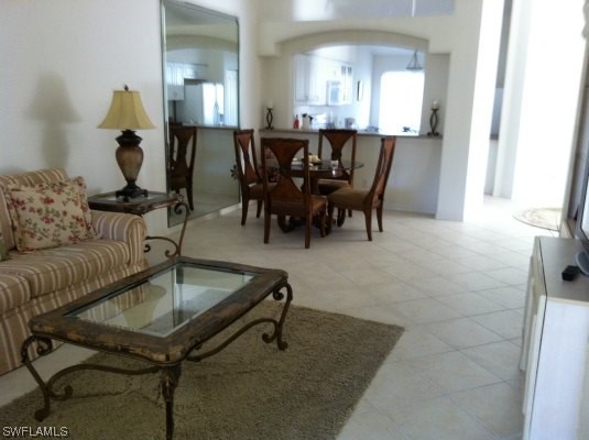 8088 Ibis Cove Circle, Unit 804 Naples, FL 34119 - Photo 15 of 27 a living room with furniture a dining table and a potted plant