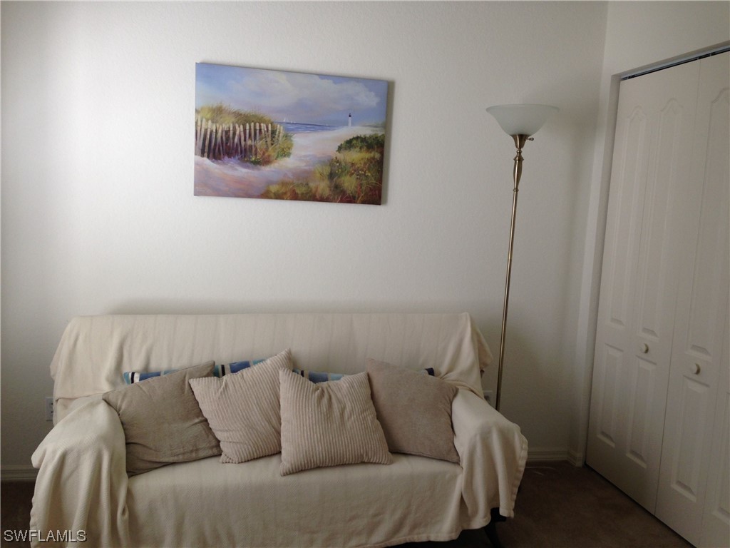 8088 Ibis Cove Circle, Unit 804 Naples, FL 34119 - Photo 16 of 27 a bed sitting in a bedroom next to a small bathroom