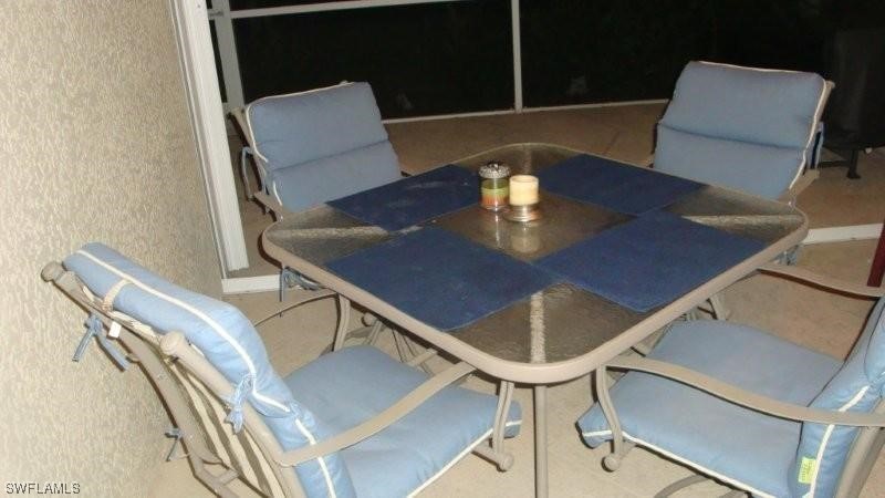 8088 Ibis Cove Circle, Unit 804 Naples, FL 34119 - Photo 22 of 27 a view of a dining room with furniture and wooden floor