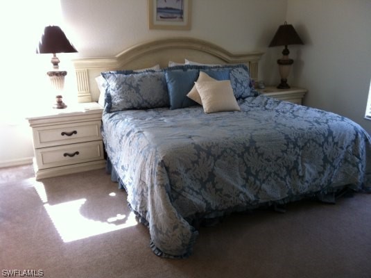 8088 Ibis Cove Circle, Unit 804 Naples, FL 34119 - Photo 10 of 27 a bedroom with a bed and a lamp on dresser