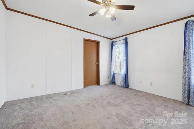 an empty room with a ceiling fan and a window
