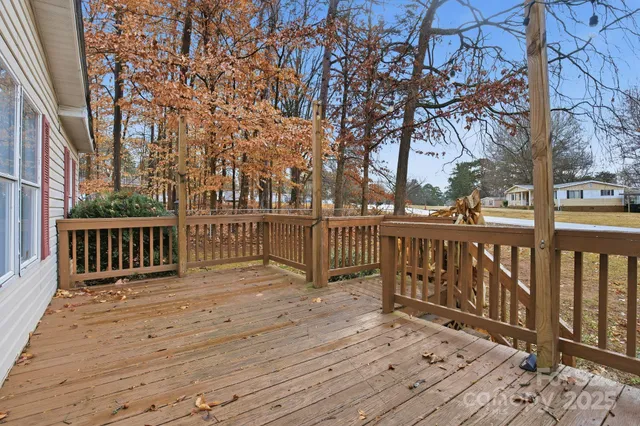 a view of deck with wooden floor and fence and trees