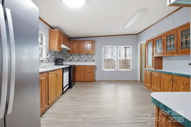 a kitchen with stainless steel appliances granite countertop a stove a sink and a refrigerator