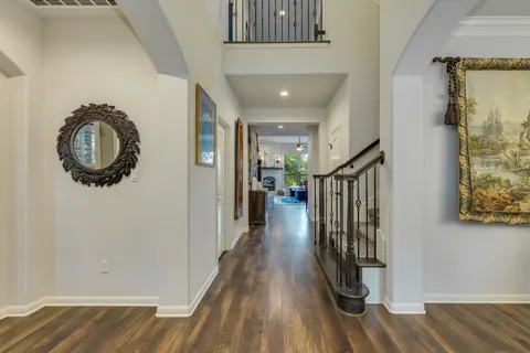 a view of a hallway with wooden floor and staircase