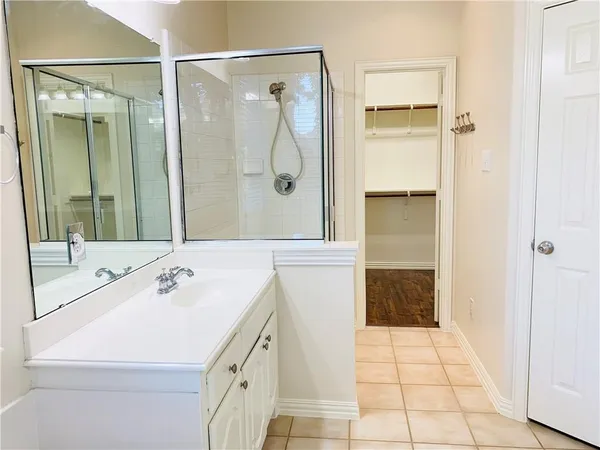 a bathroom with a sink a shower and a mirror