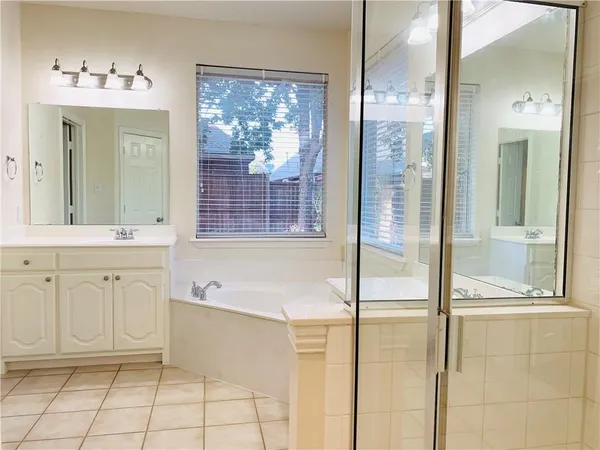 a bathroom with a bathtub sink and mirror