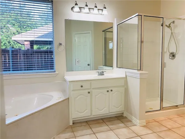 a bathroom with a bathtub sink vanity and mirror