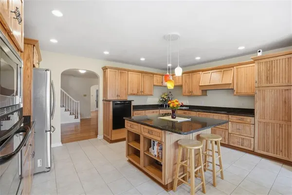 a kitchen with stainless steel appliances granite countertop a stove a sink and a refrigerator
