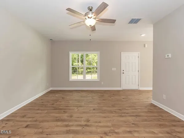 wooden floor in an empty room with a window