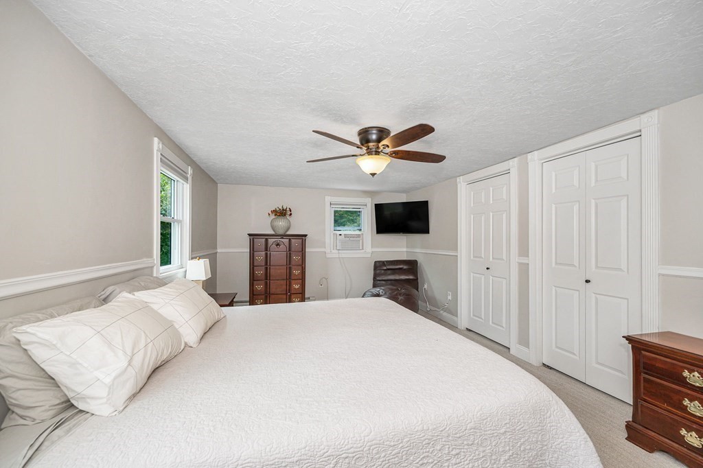 21 Sherwood Road Wilmington, MA 01887 - Photo 18 of 42 a bedroom with a large bed and a flat tv screen