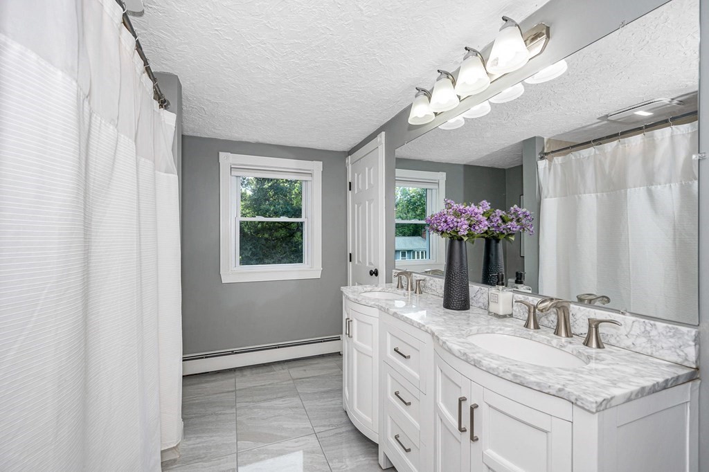 21 Sherwood Road Wilmington, MA 01887 - Photo 23 of 42 a bathroom with a granite countertop sink a large mirror and a window