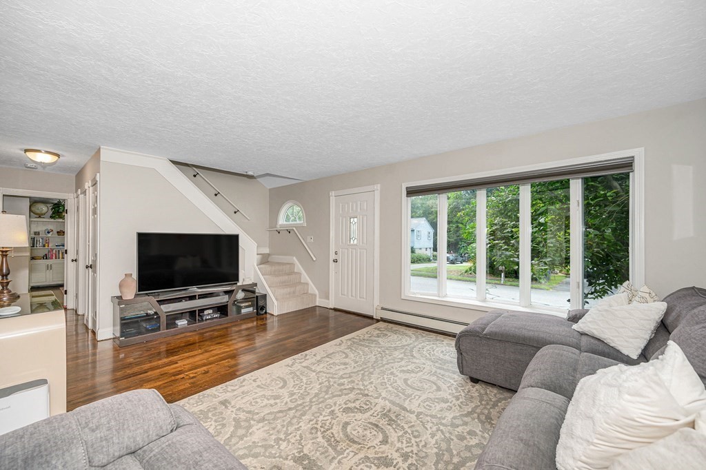 21 Sherwood Road Wilmington, MA 01887 - Photo 6 of 42 a living room with furniture a flat screen tv and a large window