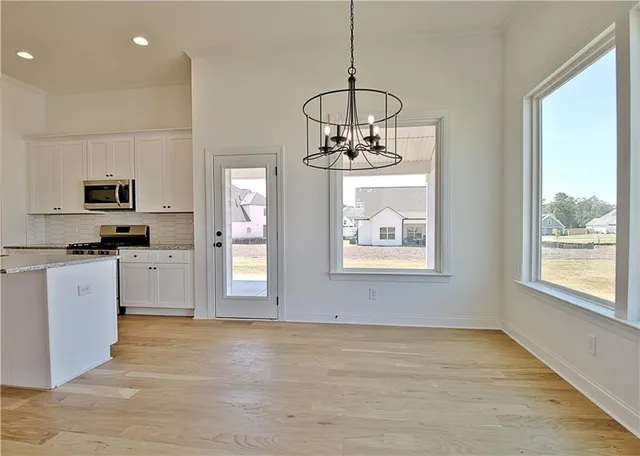 a kitchen with stainless steel appliances granite countertop a stove a sink and white cabinets