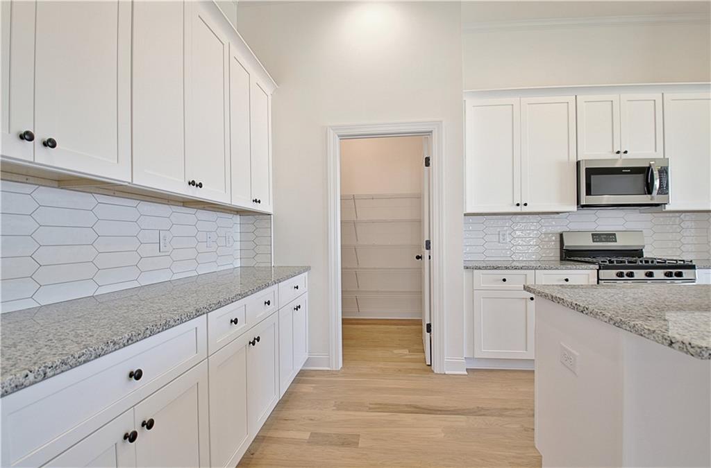 115 Rutland Court Senoia, GA 30276 - Photo 20 of 69 a kitchen with granite countertop white cabinets and stainless steel appliances