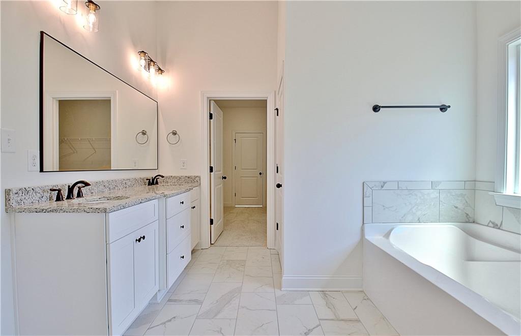 115 Rutland Court Senoia, GA 30276 - Photo 30 of 69 a spacious bathroom with a granite countertop sink a mirror and a bathtub