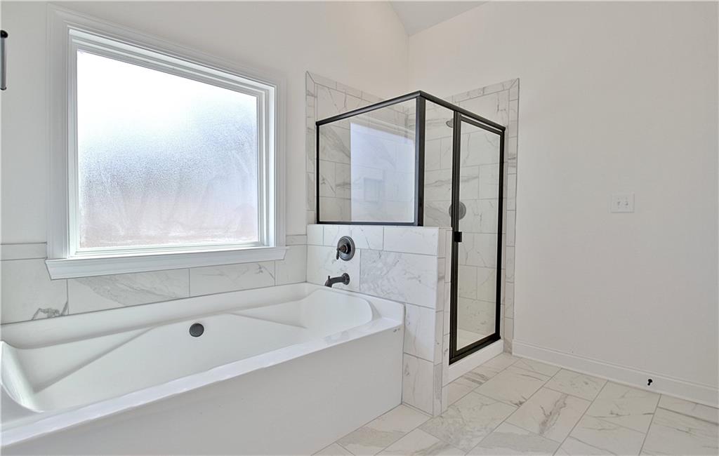 115 Rutland Court Senoia, GA 30276 - Photo 31 of 69 a bathroom with a bathtub and a shower