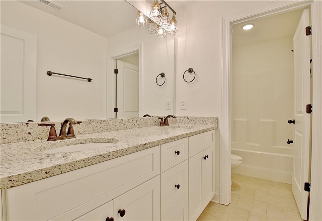 115 Rutland Court Senoia, GA 30276 - Photo 50 of 69 a bathroom with a granite countertop sink and a mirror