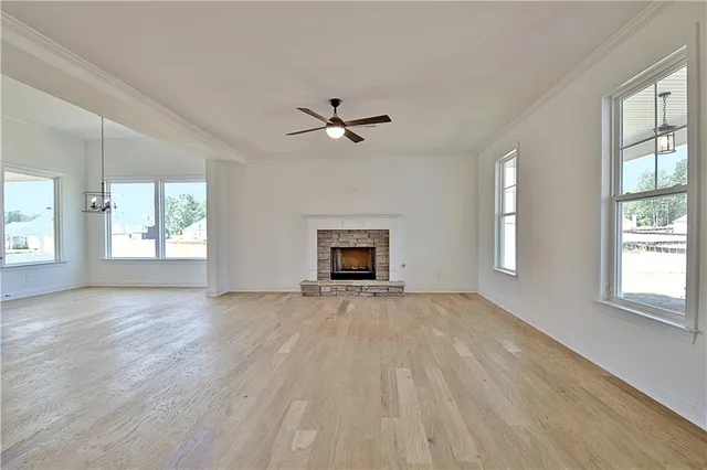 a view of kitchen and empty room with wooden floor