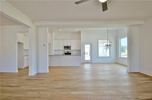 a view of a kitchen with wooden floor and electronic appliances