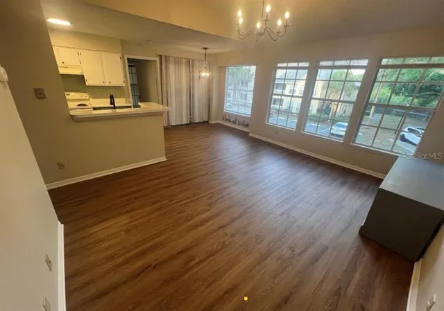 a view of a kitchen with wooden floor and a window
