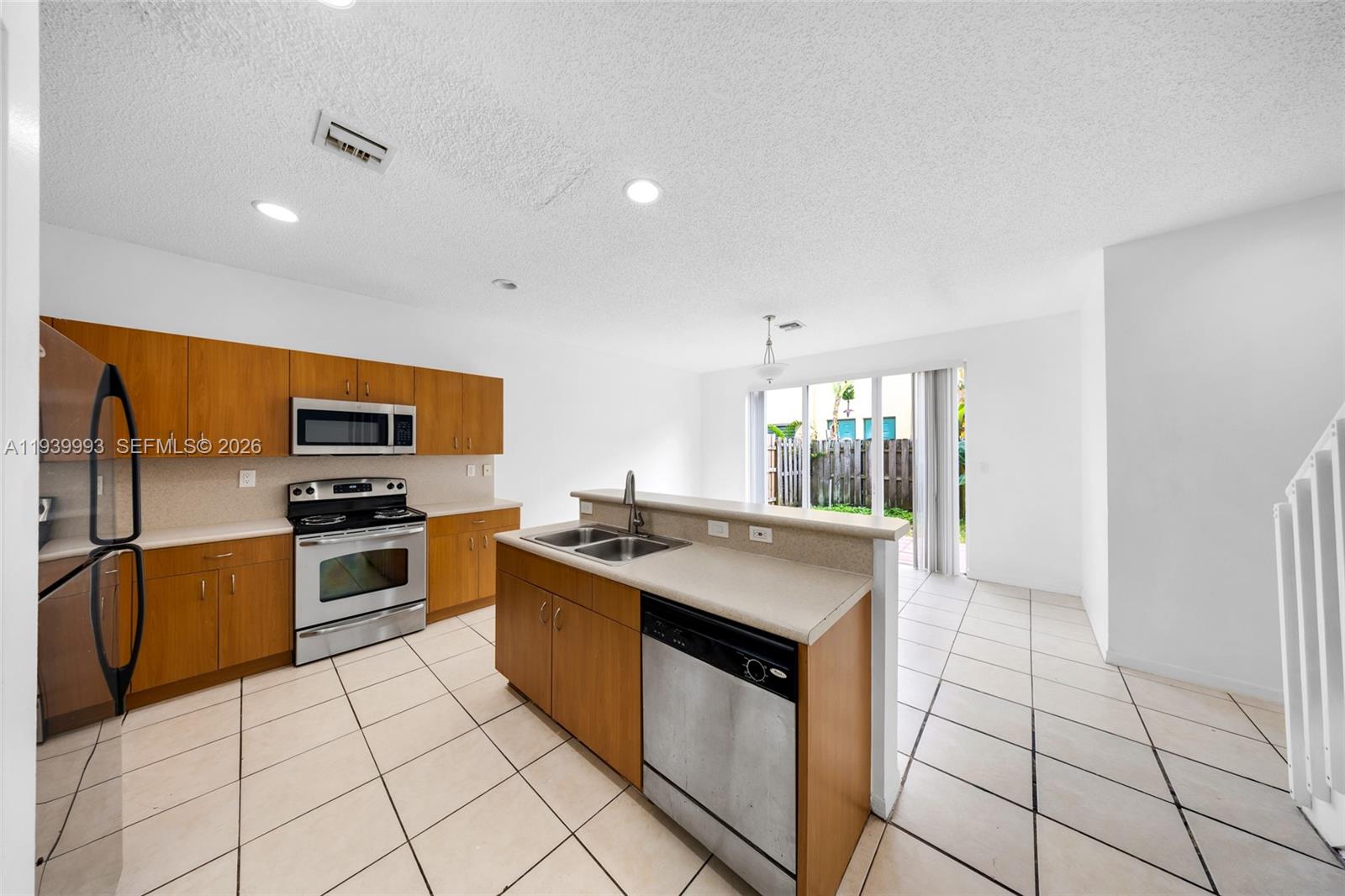 951 Northeast 42nd Terrace, Unit 951 Homestead, FL 33033 - Photo 12 of 30 a kitchen with stainless steel appliances granite countertop a stove top oven and sink
