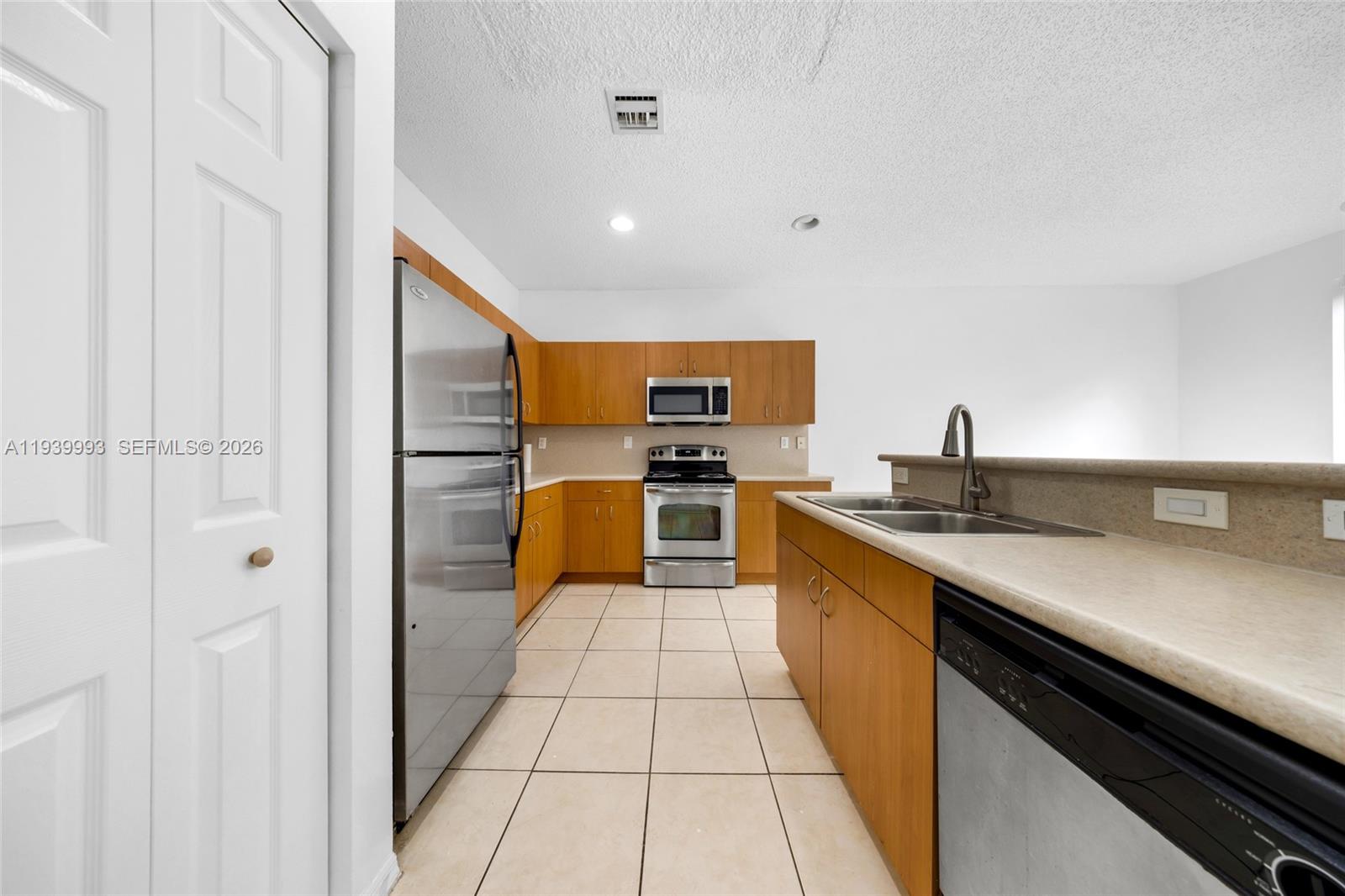 951 Northeast 42nd Terrace, Unit 951 Homestead, FL 33033 - Photo 13 of 30 a large kitchen with stainless steel appliances kitchen island granite countertop a refrigerator and a sink