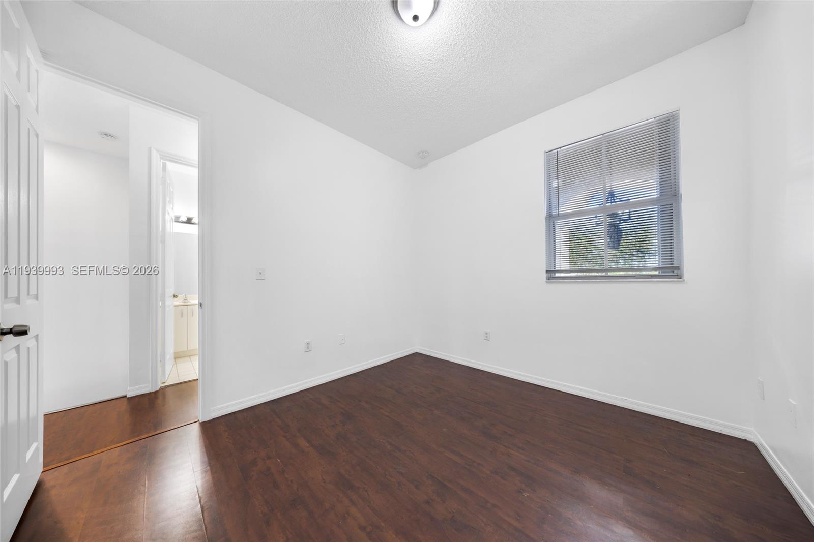 951 Northeast 42nd Terrace, Unit 951 Homestead, FL 33033 - Photo 23 of 30 an empty room with wooden floor and windows