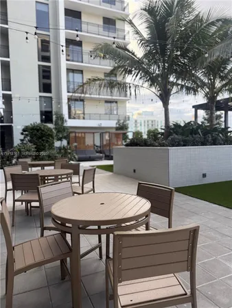 a view of a patio with table and chairs and potted plants