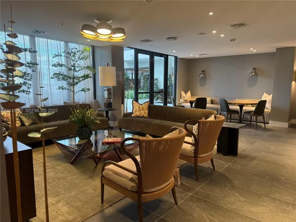a living room with furniture a chandelier and a large window