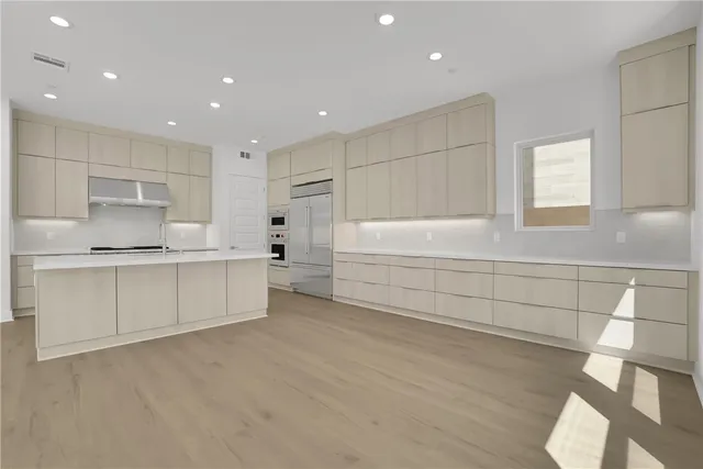 a view of a kitchen with white cabinets and wooden floor