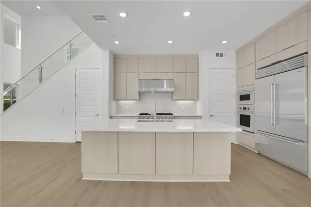 a kitchen with kitchen island a sink stainless steel appliances and cabinets