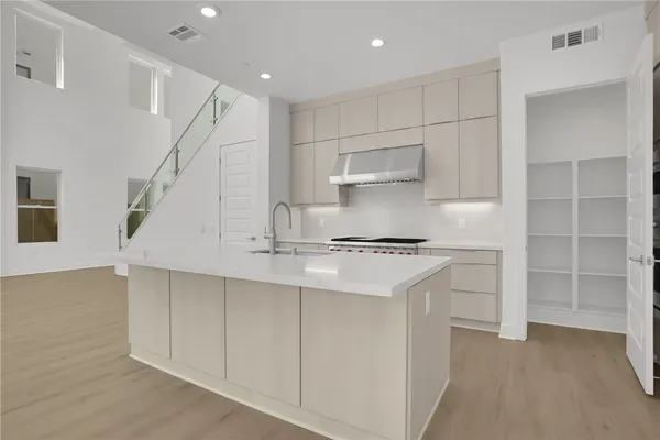 a kitchen with kitchen island a sink stainless steel appliances and cabinets